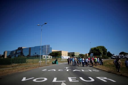 French dairy farmers from the FNSEA union gather near a message that reads, "Lactalis Thief" as they block the round-about access to the Lactalis plant to protest against the price of milk in Laval, France, August 23, 2016. REUTERS/Stephane Mahe