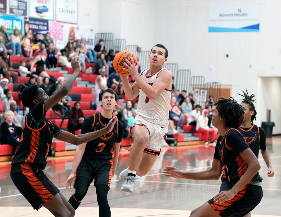 New Smyrna Beach's Josh Reik makes the pass under the basket during a game with Spruce Creek, Friday, Dec.15, 2023.