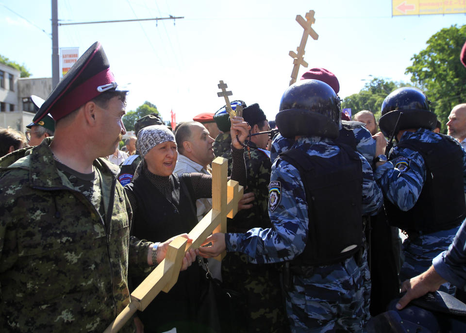 FILE - Riot police stops Orthodox believers who are trying to stop Ukraine's first gay pride demonstration in Kyiv, Ukraine, Saturday, May 25, 2013. Despite the war in Ukraine, the country's largest LGBT rights event, KyivPride, is going ahead on Saturday, June 25, 2022. But not on its native streets and not as a celebration of gay pride. It will instead join Warsaw's yearly Equality Parade, using it as a platform to keep international attention focused on the Ukrainian struggle for freedom. (AP Photo/Sergei Chuzavkov, File)