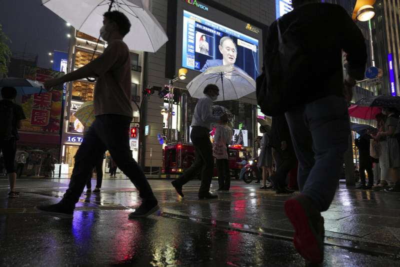 東京鬧區街頭的大螢幕上，正在播放菅義偉宣布東京將在7月12日進入第四波緊急事態的記者會。（美聯社）