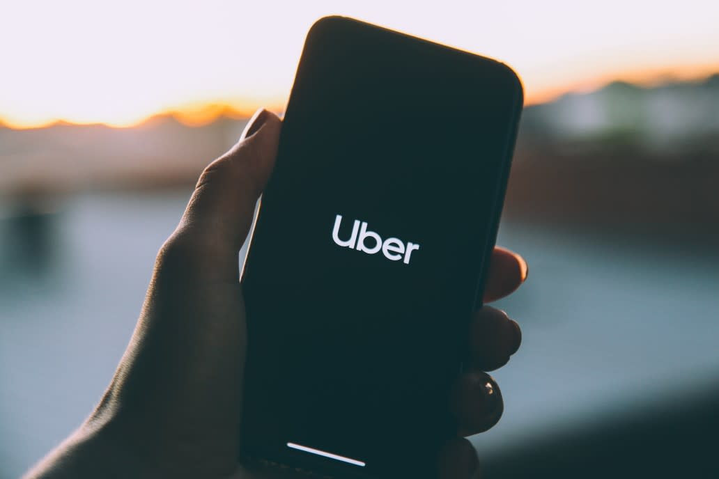 person holding phone with Uber logo on screen