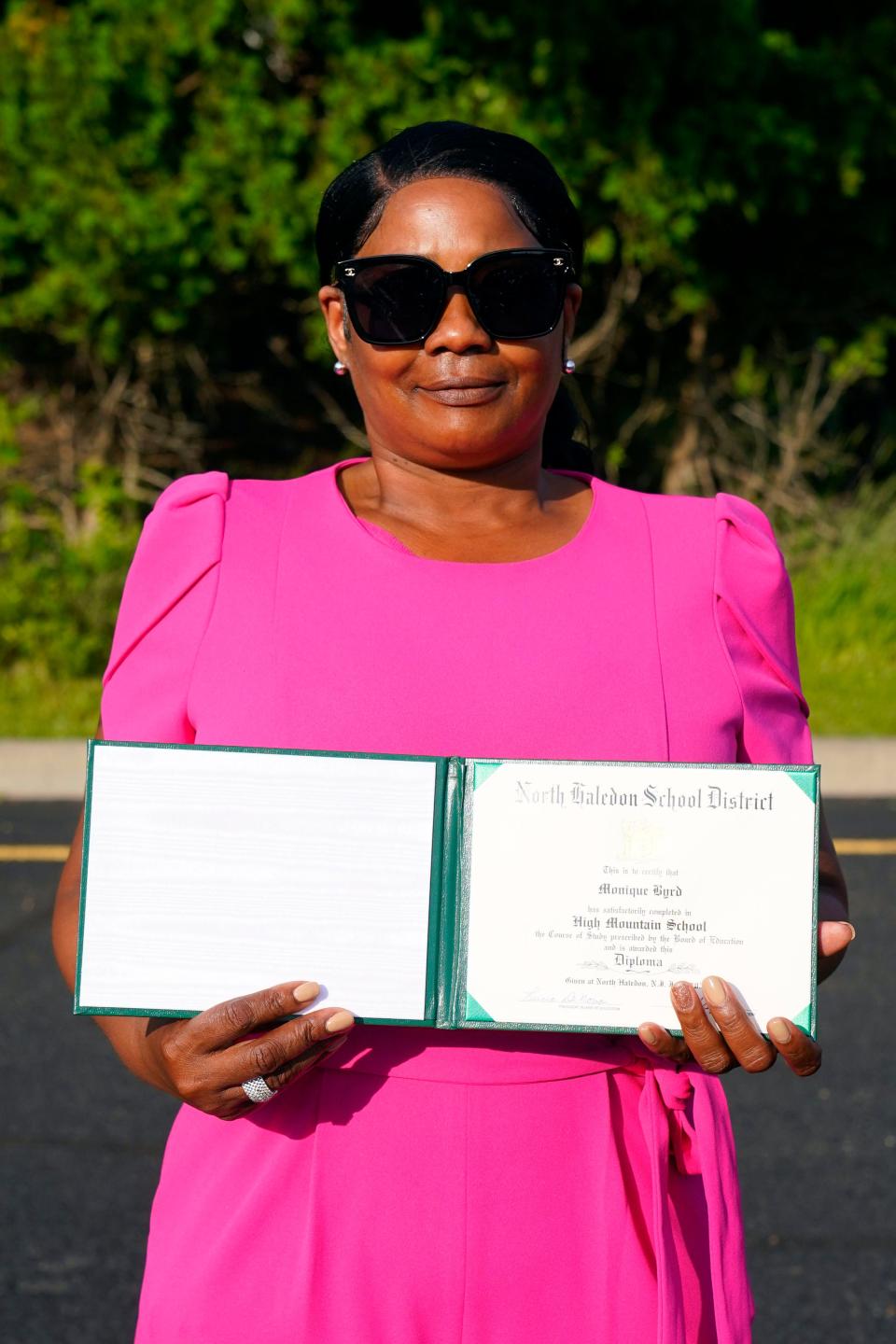 Latasha Reed holds her daughter's eighth grade diploma during the graduation ceremony at High Mountain School on Monday, June 20, 2022. Reed's 15-year-old daughter, Monique Byrd, was fatally shot by stray bullets in Paterson in May of this year. 