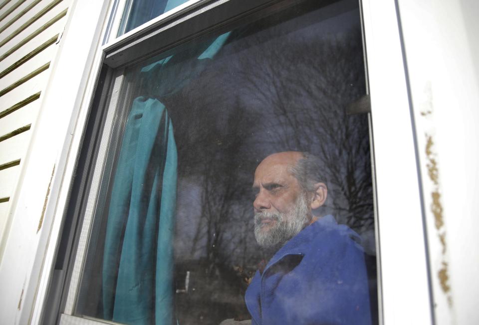 In this Sunday, Dec. 11, 2016 photo U.S. Navy veteran Stephen Matthews, 55, sits for a photograph in the bedroom of a relatives home, in Warwick, R.I. Matthews fell in his driveway in 2015, injuring his neck resulting in him getting laid off from his job. After being evicted he and his wife temporarily lived in their car while his children went to live with a relative. The relative then let Matthews and his wife come too. Matthews said he received a voucher that would pay about two-thirds of his rent, but struggled to find an apartment in Rhode Island where he could afford the balance. He got one in West Warwick, R.I. in late December 2016 after a six-month search. (AP Photo/Steven Senne)