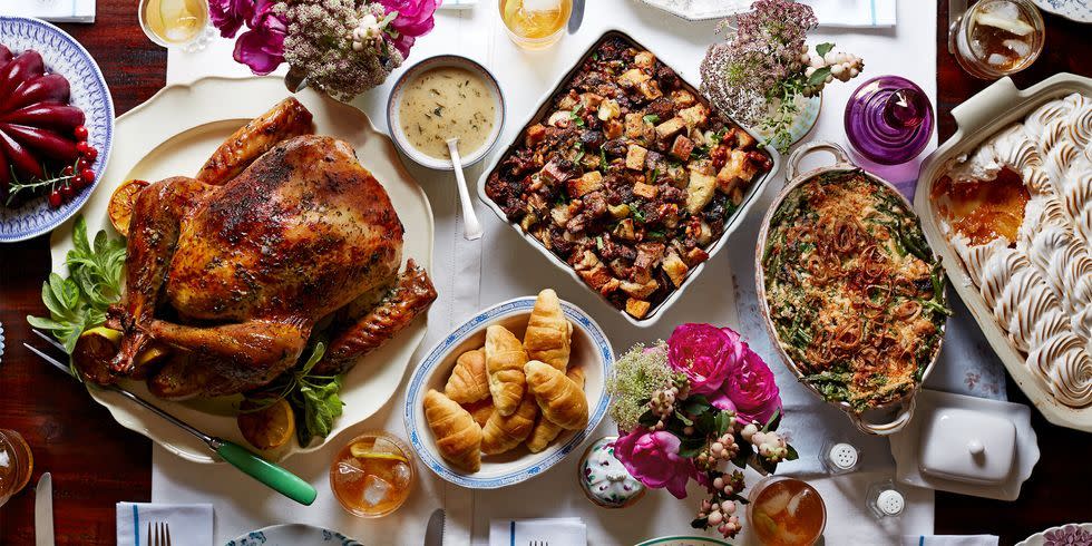 overhead view of thanksgiving feast on a table with turkey, molded cranberry salad, gravy, crescent rolls, dressing