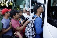 FILE PHOTO: Migration officers guide migrants, mainly from Central America and marching in a caravan, towards a vehicle near Frontera Hidalgo, Chiapas