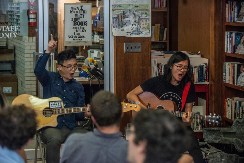 Simon Tam, left, and Joe X. Jiang of The Slants get the audience to sing with them at Read Herring Bookstore in Montgomery on Wednesday, July 17, 2019.