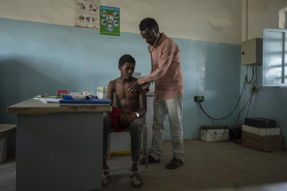 Surgeon and doctor-turned-refugee, Dr. Tewodros Tefera, checks a Tigrayan refugee inside the Sudanese Red Crescent (SRC) Clinic, at Hamdeyat Transition Center near the Sudan-Ethiopia border, eastern Sudan, March 17, 2021. (AP Photo/Nariman El-Mofty)