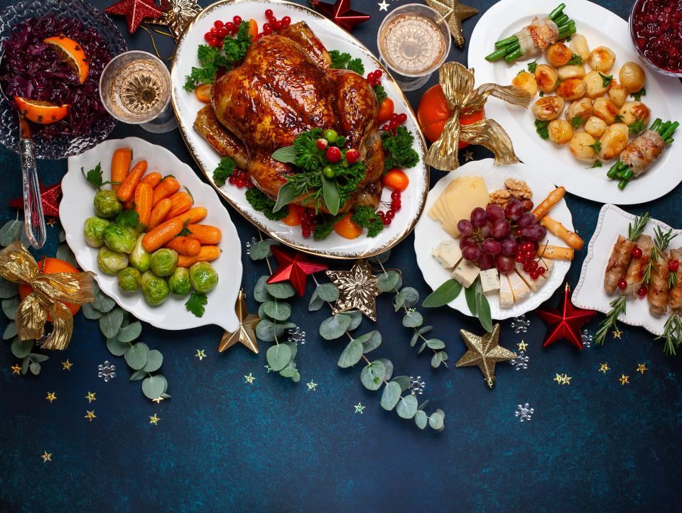 A top view of a table with a roasted chicken and various vegetables dishes.