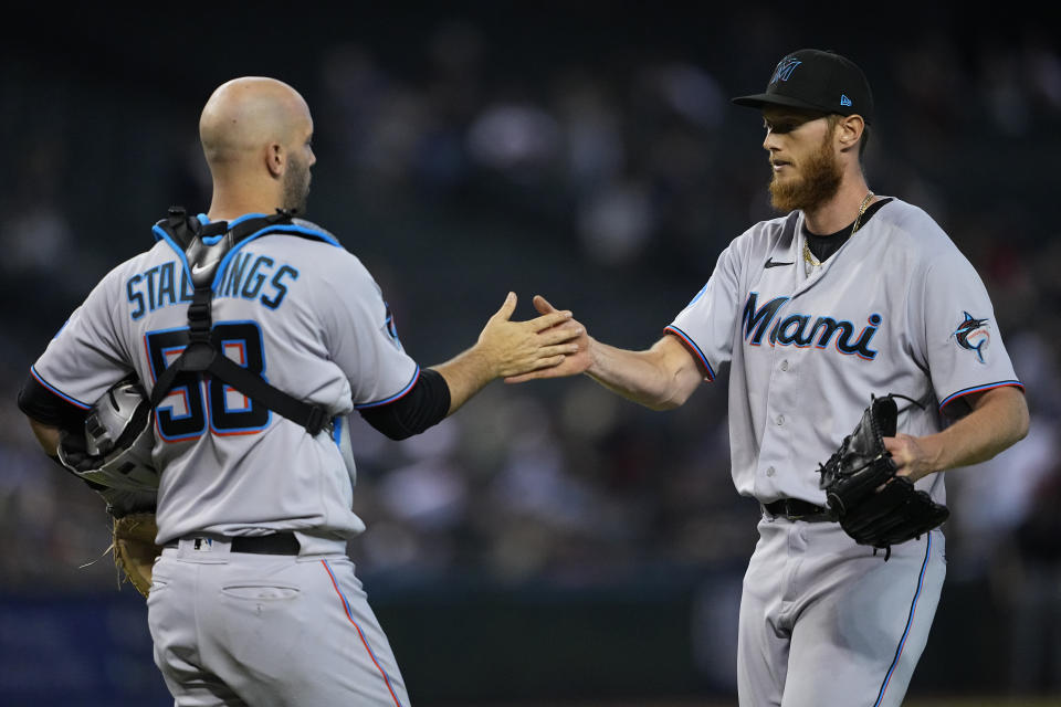 Miami Marlins catcher Jacob Stallings greets relief pitcher A.J. Puk after a baseball game against the Arizona Diamondbacks, Wednesday, May 10, 2023, in Phoenix. The Marlins defeated the Diamondbacks 5-4. (AP Photo/Matt York)