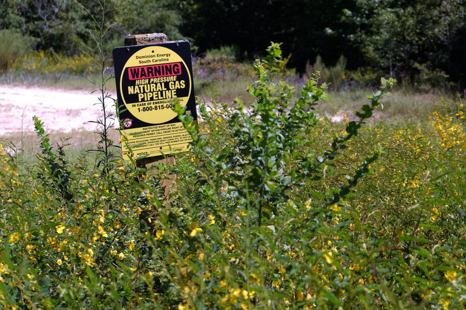 A sign marks an existing Dominion Energy natural gas pipeline along the Great Pee Dee River Monday Aug. 17, 2020 in Pamplico, S.C. Dominion plans to build a new 14.5-mile-long gas line along the river and cites new energy demand spurred by economic growth in eastern South Carolina as the impetus for the project. (AP Photo/Michelle Liu)