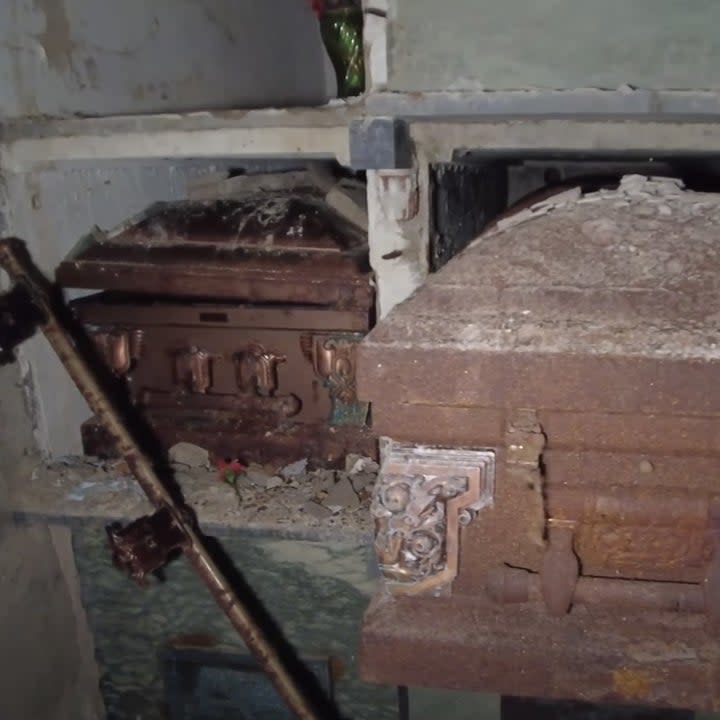 A coffin hanging out of a crypt