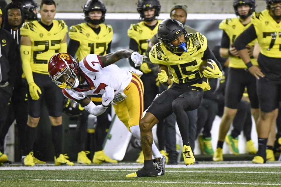 Image of Oregon wide receiver Tez Johnson, right, avoiding USC cornerback Domani Jackson after making a catch.