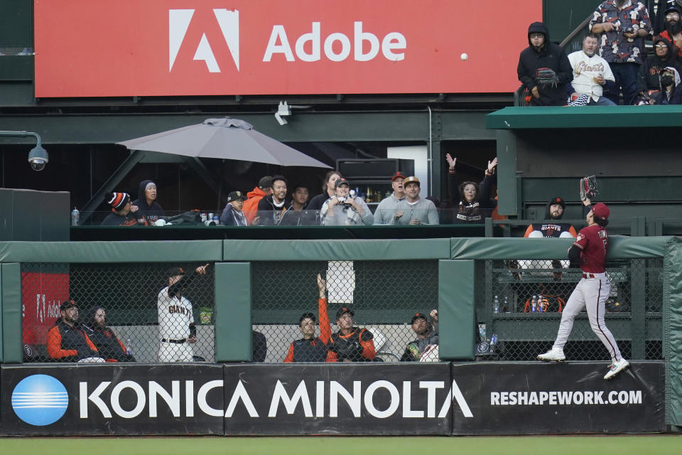 Arizona Diamondbacks center fielder Alek Thomas attempts to catch a solo home run hit by San Francisco Giants' LaMonte Wade Jr. during the third inning of a baseball game in San Francisco, Wednesday, Aug. 17, 2022. (AP Photo/Godofredo A. Vásquez)