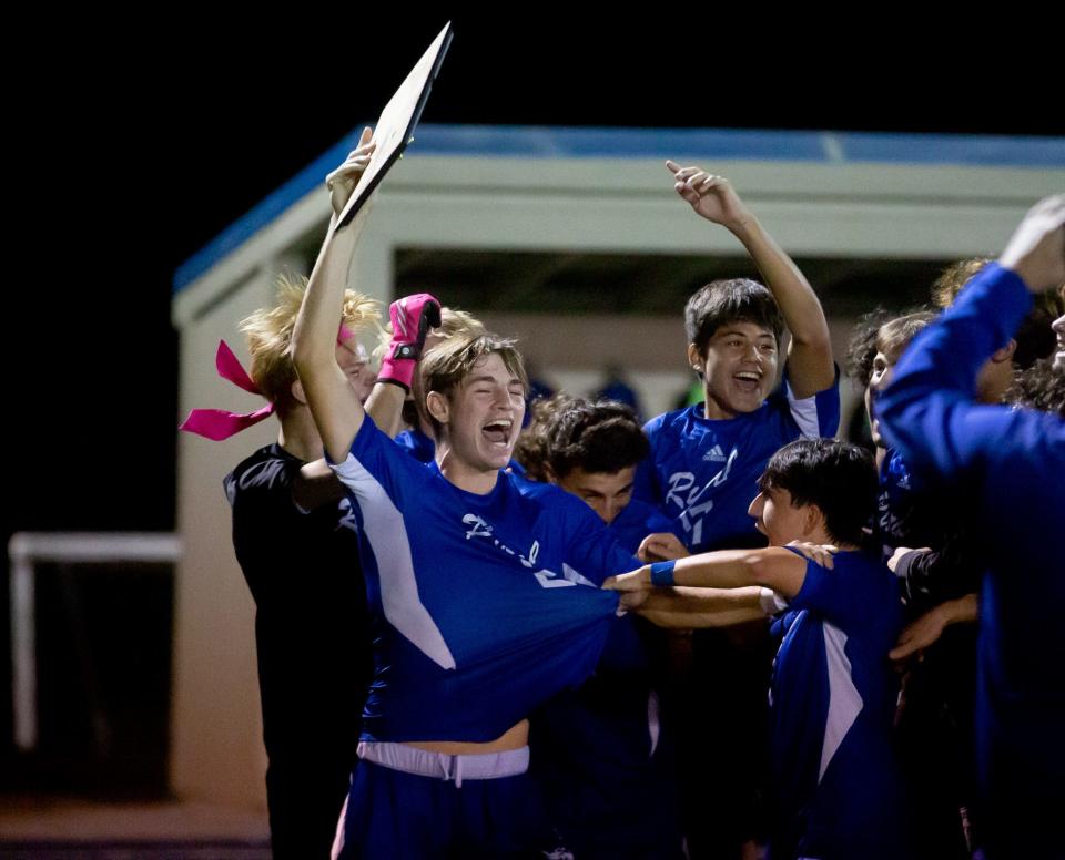 Washburn Rural celebrates with the regional plaque after defeating Free State on Thursday, Oct. 26.