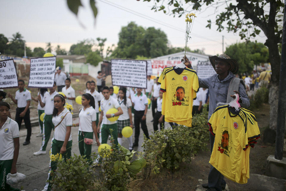 A man sells jerseys of Colombia's soccer team stamped with photos of the late Nobel Literature laureate Gabriel Garcia Marquez during a symbolic funeral parade in Aracataca, his hometown in Colombia's Caribbean coast, Monday, April 21, 2014. Garcia Marquez died at the age of 87 in Mexico City on April 17, 2014. (AP Photo/Ricardo Mazalan)