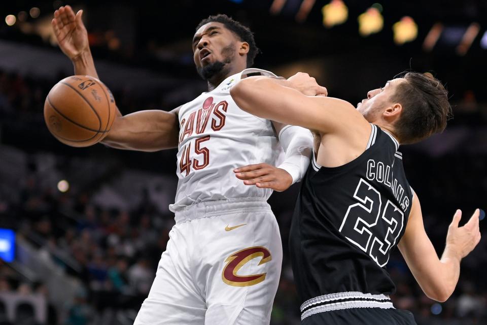 Cleveland Cavaliers' Donovan Mitchell (45) collides with San Antonio Spurs' Zach Collins during the first half of an NBA basketball game, Monday, Dec. 12, 2022, in San Antonio. (AP Photo/Darren Abate)