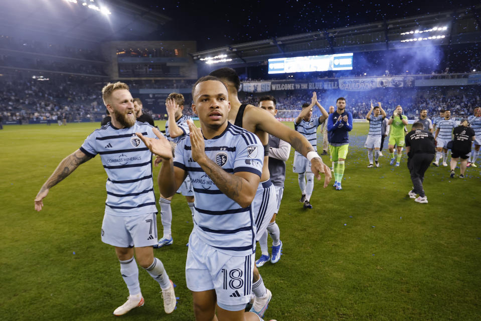 Sporting Kansas City's Johnny Russell (7) and Logan Ndenbe (18) celebrate with teammates at the end of an MLS playoff soccer match against St. Louis City, Sunday, Nov. 5, 2023, in Kansas City, Kan. (AP Photo/Colin E. Braley)