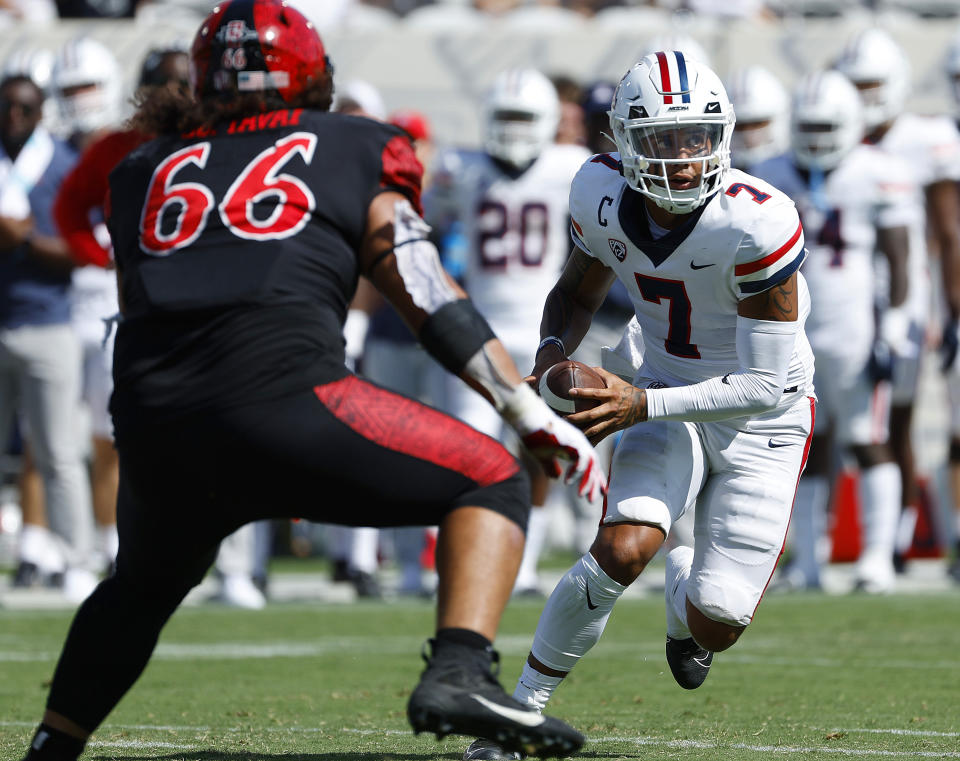 Arizona quarterback Jayden de Laura gets ready to pitch the ball to DJ Williams who scored a touchdown as San Diego State's Jonah Tavai defends during the fourth quarter of an NCAA college football game Saturday, Sept. 3, 2022 in San Diego. (K.C. Alfred/The San Diego Union-Tribune via AP)