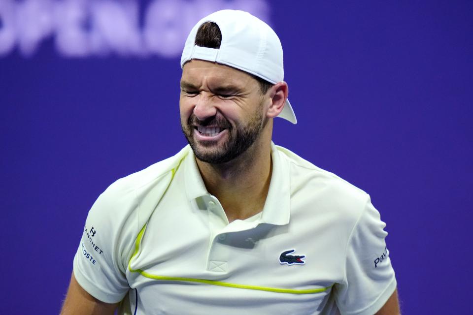 Grigor Dimitrov, of Bulgaria, winces during the fourth set of his match against Frances Tiafoe shortly before retiring with an apparent injury (AP)