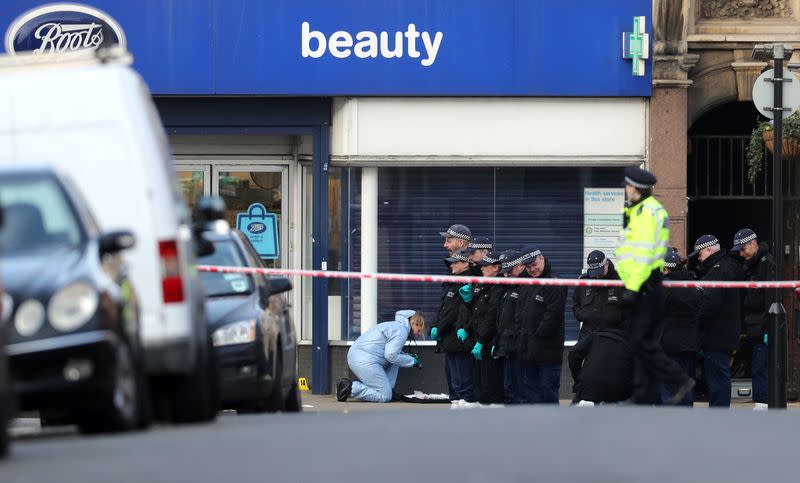 Police officers and forensic officer are seen near the site where a man was shot by armed officers in Streatham, south London