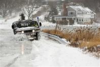 A police vehicle drives through a flooded street during a winter nor'easter snow storm in Scituate, Massachusetts January 3, 2014. REUTERS/Dominick Reuter