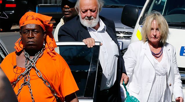 A protester with chains (left) looks on as Barry (centre) and June Steenkamp, the parents of Reeva Steenkamp, arrive ahead of South African Olympic and Paralympic sprinter Oscar Pistorius' sentencing at the North Gauteng High Court in Pretoria. Photo: REUTERS