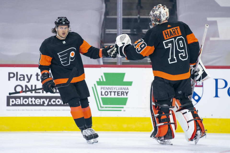 Philadelphia Flyers' Travis Konecny, left, celebrates his goal with goaltender Carter Hart, right, during the first period of an NHL hockey game against the Pittsburgh Penguins, Friday, Jan. 15, 2021, in Philadelphia. (AP Photo/Chris Szagola)