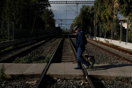 A man crosses railway tracks during a 24-hour general strike in Athens, Greece, November 28, 2018.REUTERS/Costas Baltas