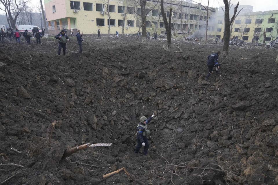 Ukrainische Soldaten und Notfallhelfer arbeiten an der Seite des durch Beschuss beschädigten Entbindungskrankenhauses in Mariupol, Ukraine. 9. März 2022. 