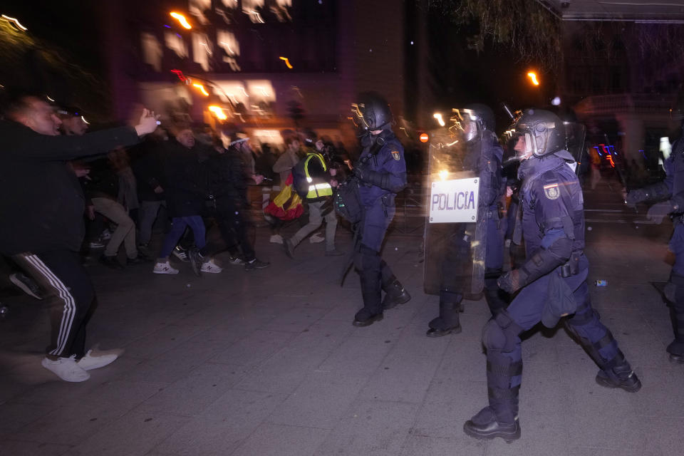 Riot police clash with demonstrators after a a protest against the amnesty at the headquarters of Socialist party in Madrid, Spain, Thursday, Nov. 16, 2023. Spain's acting Socialist prime minister, Pedro Sánchez, has been chosen by a majority of legislators to form a new leftist coalition government in a parliamentary vote. The vote came after nearly two days of debate among party leaders that centered almost entirely on a highly controversial amnesty deal for Catalonia's separatists that Sánchez agreed to in return for vital support to get elected prime minister again. (AP Photo/Manu Fernandez)