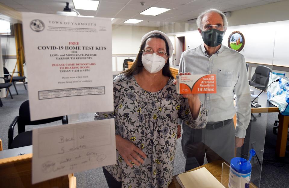Yarmouth Health Director Bruce Murphy, right, and Mary Waygan, a town community development program coordinator, offer a COVID-19 test kit at Yarmouth Town Hall in 2021.
