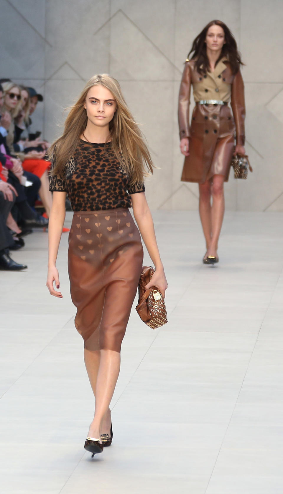 British model Cara Delevingne, left, Model Of The Year at the 2012 British Fashion Awards, wears a design created by Burberry Prorsum, during London Fashion Week, at Kensington Gardens in west London, Monday, Feb. 18, 2013. (Photo by Joel Ryan/Invision/AP)