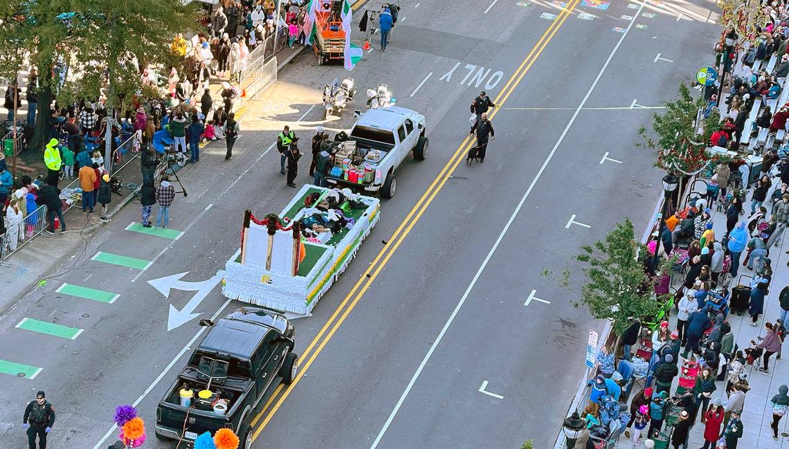 Police tape off the scene where a white truck pulling a float went out of control at the Raleigh Christmas Parade Saturday, Nov. 19, 2022, crashing into parade participants and injuring at least one person.
