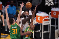 Los Angeles Lakers center Montrezl Harrell, center, shoots as Utah Jazz forward Georges Niang, left, and guard Trent Forrest defend during the first half of an NBA basketball game Saturday, April 17, 2021, in Los Angeles. (AP Photo/Mark J. Terrill)