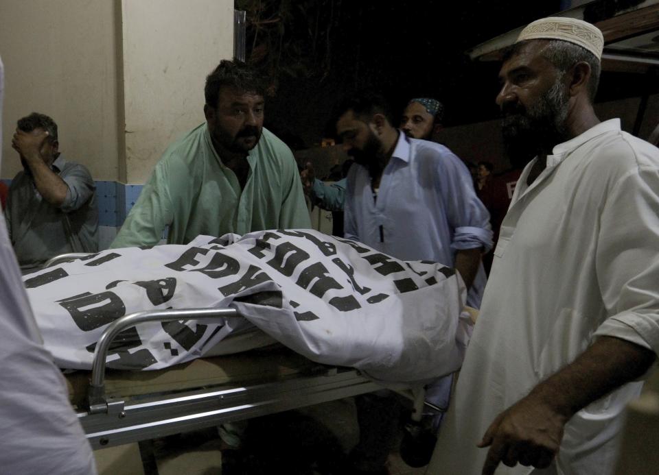 People transport a body of their relative, who died in a boat capsized, outside of a morgue in Karachi, Pakistan, Monday, Aug. 17, 2020. A small boat carrying members from a Pakistani family capsized in Keenjhar Lake in southern Sindh province on Monday, leaving some people dead and few missing, police said. (AP Photo/Fareed Khan)