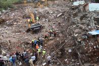 Rescue workers search for survivors in the rubble of a collapsed five-storey apartment building in Mahad. (Photo by PUNIT PARANJPE/AFP via Getty Images)