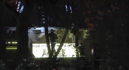 French firefighters climb ladders to rescue hostages as security forces carry out an assault at the Bataclan concert hall, in Paris, France, in this still image taken from video November 14, 2015. REUTERS/Reuters TV