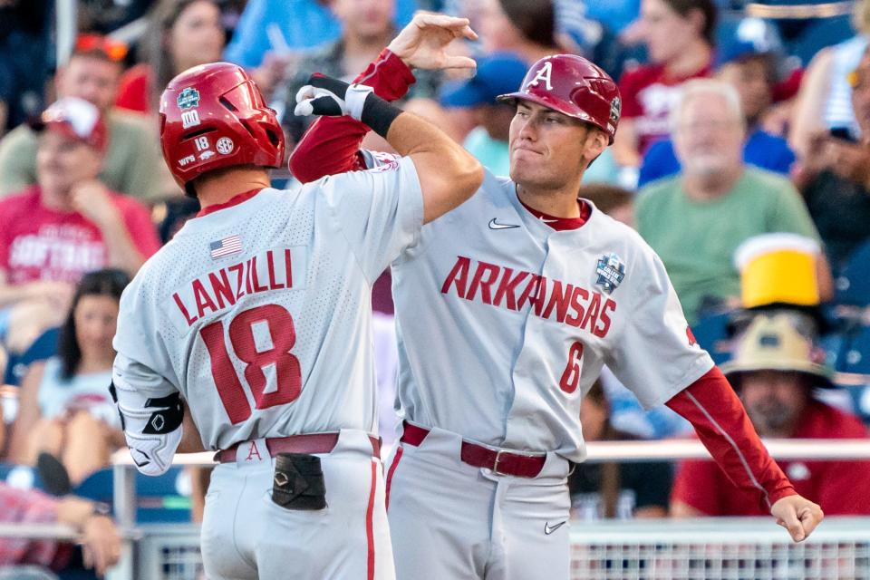 Arkansas' Chris Lanzilli (18) celebrates with assistant coach Bobby Wernes after hitting a single against Auburn.