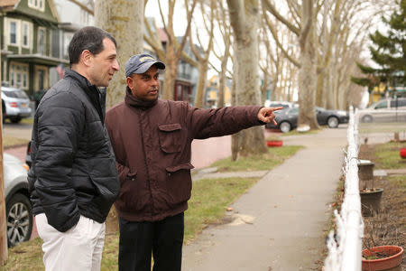 MD Chowdhury (R) stands with Tom Muscarella of the Erie County Health Department and points to improvements made to his lead contaminated home during an interview in Buffalo, New York March 30, 2017. REUTERS/Lindsay DeDario