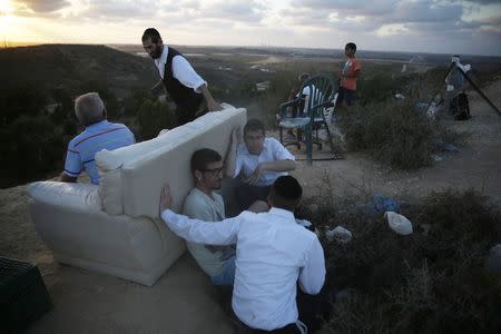 Israelis gather to look at the Gaza Strip from a hilltop near the southern town of Sderot July 15, 2014. REUTERS/Baz Ratner