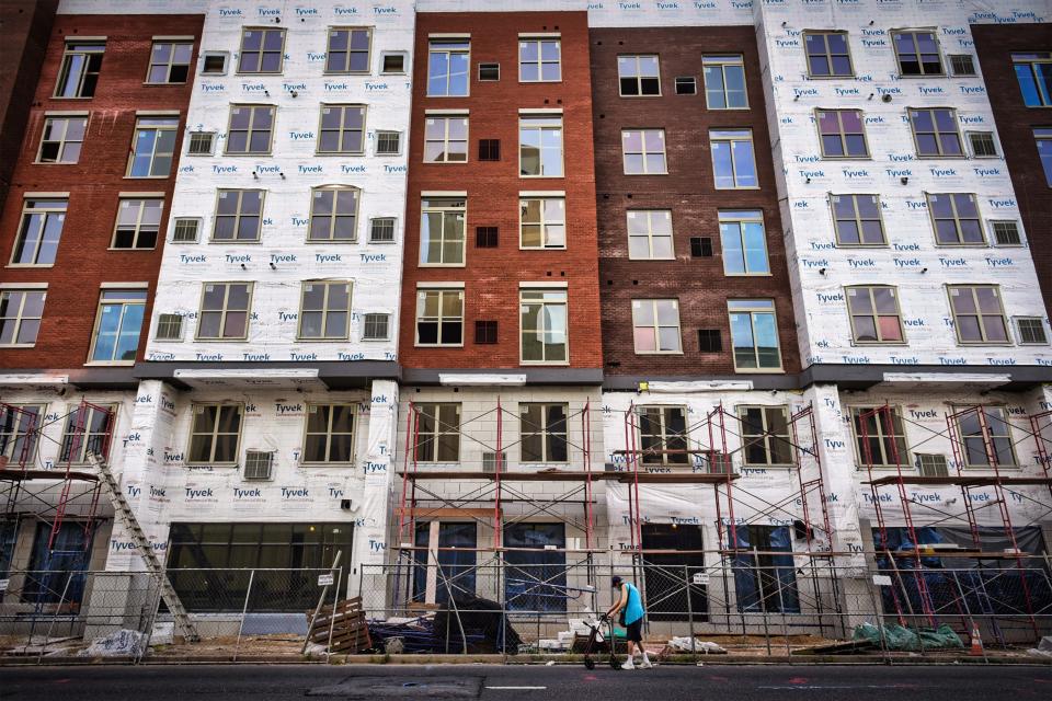 A pedestrian walks by a construction site in downtown Hackensack.