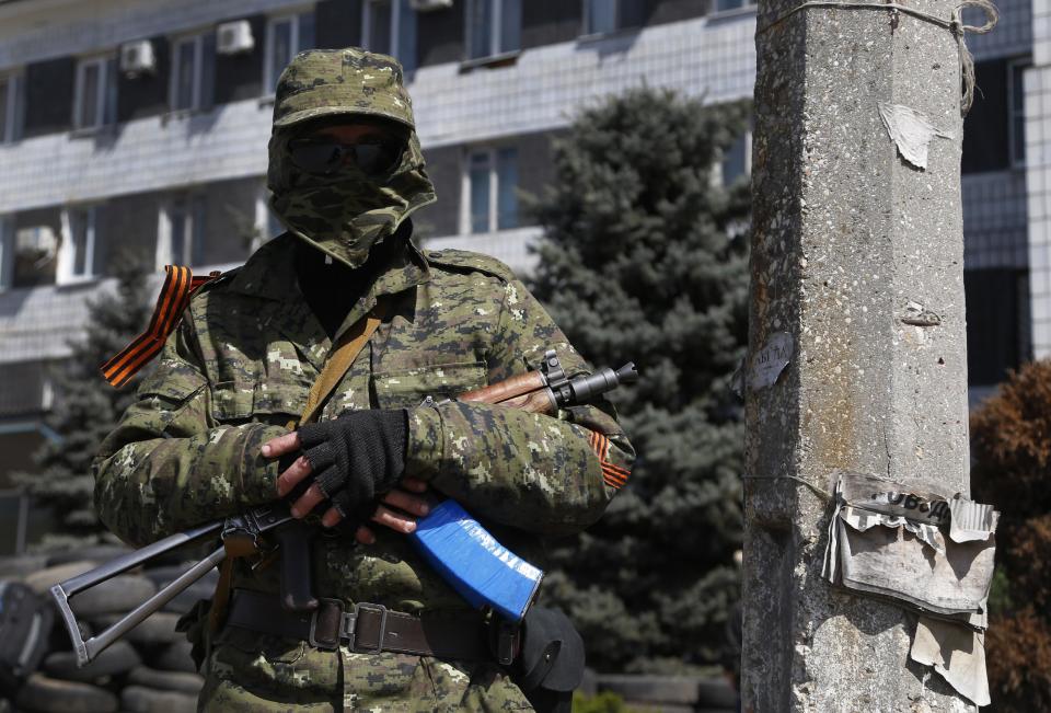 A pro Russian masked armed man guards at the city hall in Kostyantynivka, 35 kilometers (22 miles) south of Slovyansk, eastern Ukraine, Monday, April 28, 2014, after masked militants with automatic weapons seized the hall building. Ukraine's acting government and the West have accused Russia of orchestrating the unrest, which they fear Moscow could use as a pretext for an invasion. (AP Photo/Sergei Grits)