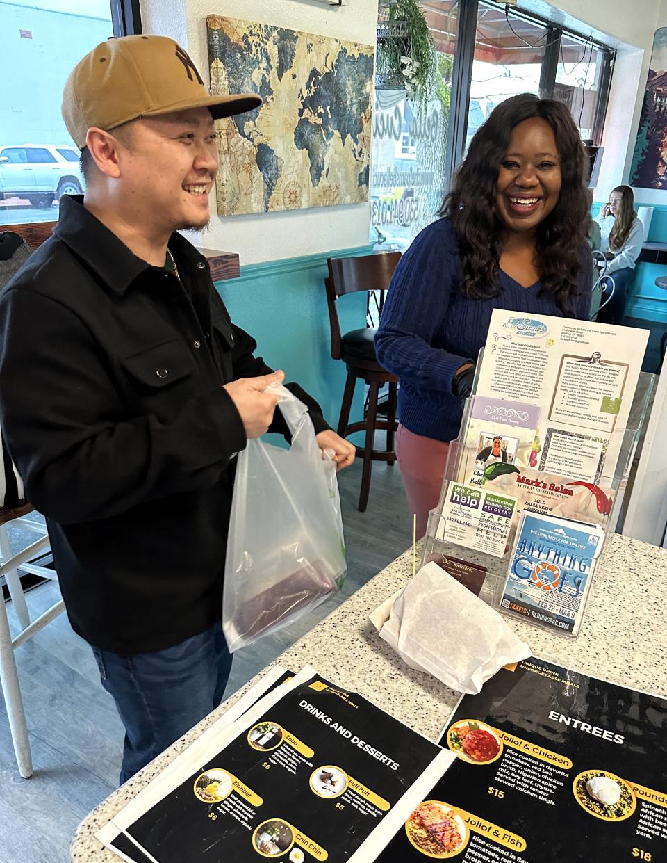 Amazing Alheri customer Kphet Menorath of Redding, left, picks up his order from employee Phebe Philips on Feb. 17, 2024.