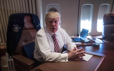US President Donald Trump poses in his office aboard Air Force One at Andrews Air Force Base in Maryland - Credit: NICHOLAS KAMM/AFP/Getty Images