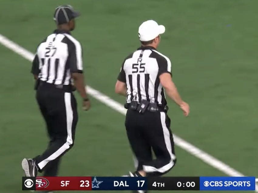 Referees jog off the field after controversial end to Cowboys-49ers game.