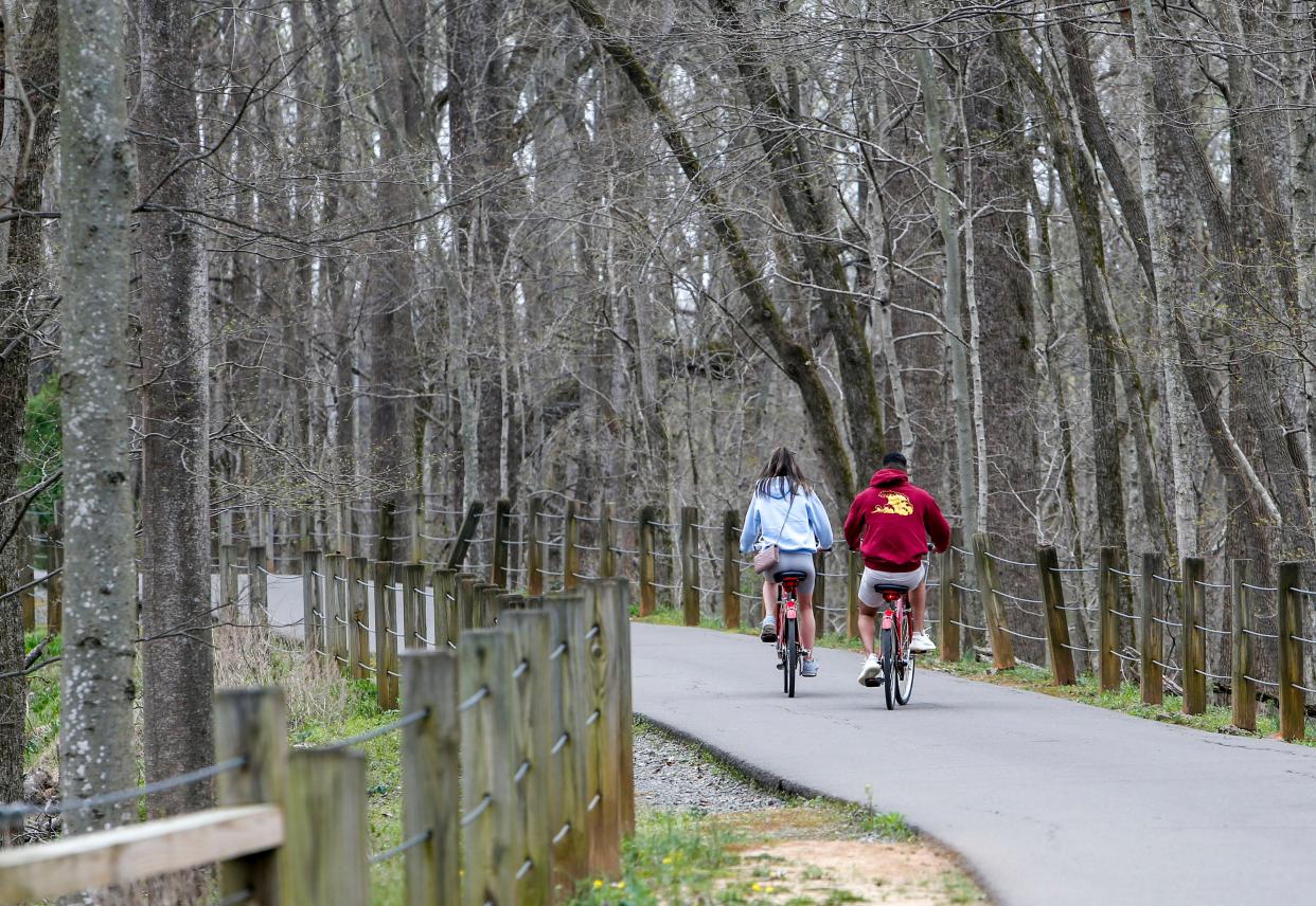 A pair of visitors ride bicycles from the Clarksville BCycle station down the trail at the Clarksville Greenway in Clarksville, Tenn., on Thursday, April 4, 2019.