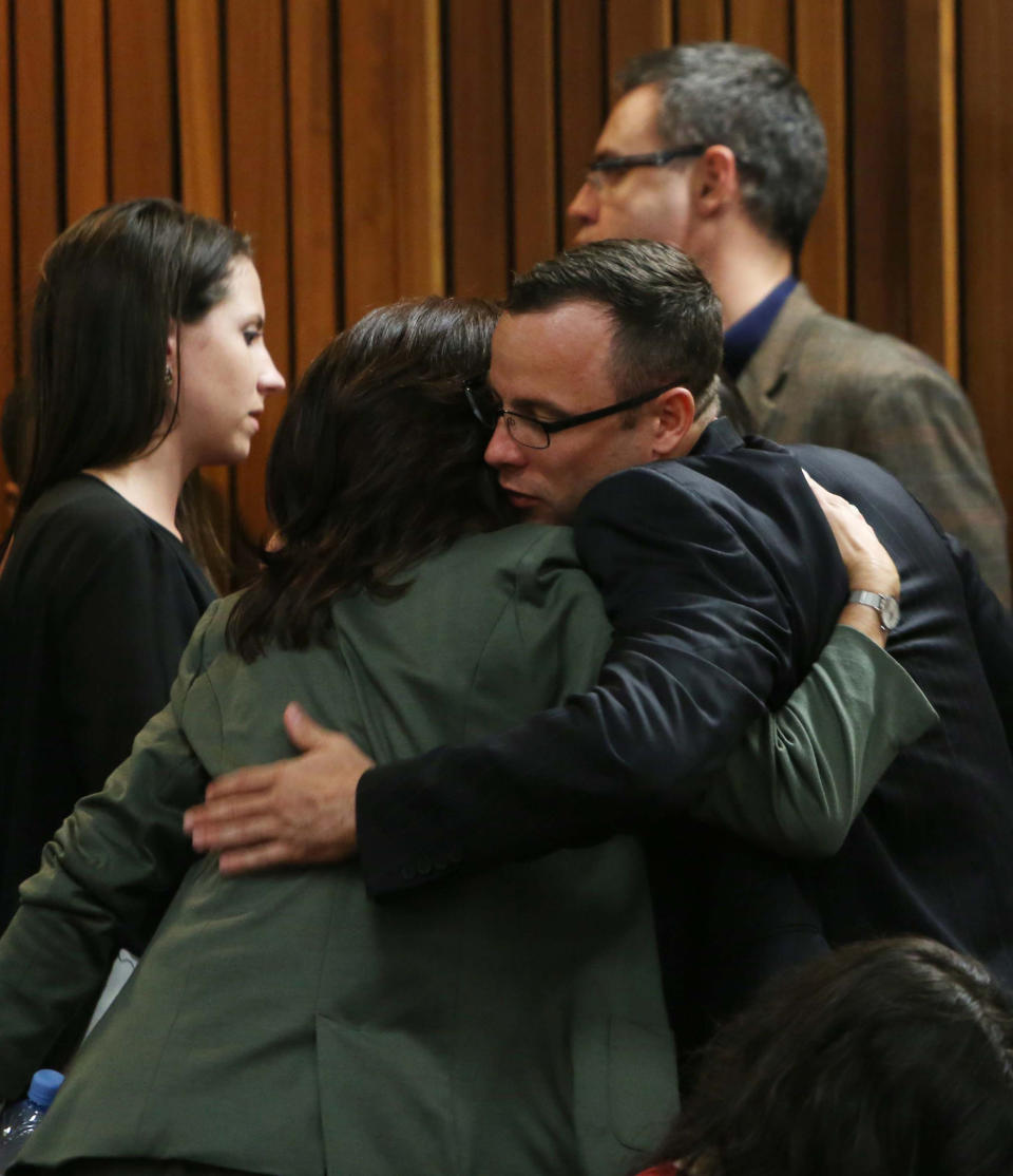 Oscar Pistorius greets and hugs family and friends as the prosecution wraps up its case in Pretoria, South Africa, Tuesday, March 25, 2014. Pistorius is charged with the Valentines Day 2013 shooting death of his girlfriend Reeva Steenkamp. (AP Photo/Esa Alexander, Pool)