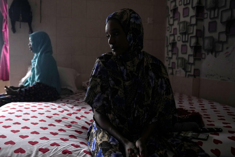 Nagad Daoud Abdallah, right, and Majdah Ishag, both from Sudan, sit on a bed in Ishag's room at a hotel turned into a shelter for refugees in Batam, an island in northwestern Indonesia, Thursday, May 16, 2024. Both have been at the community housing for eight years while waiting for resettlement in a third country. (AP Photo/Dita Alangkara)