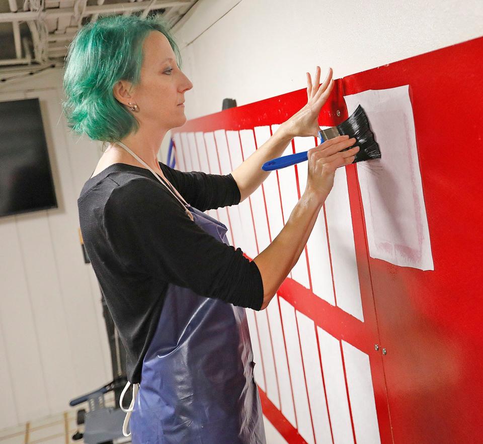 Marshfield artisan Erin Merchant MacAllister of The Paper Merchant transfers a sheet of homemade paper to the wall of her basement.