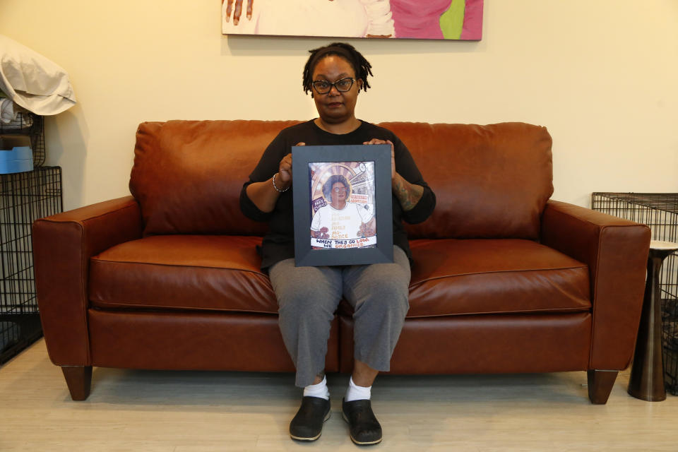 Pamela Merritt, executive director of Medical Students for Choice, sits in her living room in southern Illinois on Monday, April 11, 2022. She is holding an illustration created by a former coworker, Caitlin Blunnie, which includes one of Merritt's favorite rallying cries: "When they go low, we organize!" Merritt considers access to abortion a civil rights issue — and vows to fight to help maintain that access if the U.S. Supreme Court upholds Mississippi's ban on abortions after 15 weeks of pregnancy. Whatever that decision is, Merritt says, "There's an active, organized crew of people who are going to do what it takes to try and make sure that people aren't denied their bodily autonomy and it's not a march, it's not a rally, it's not a chant. It's different, and in many ways it does resemble some of the resistance work that took place in the late 60s, early 70s." (AP Photo/Martha Irvine)